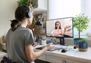 young woman participating in a trauma therapy program virtually with a female therapist